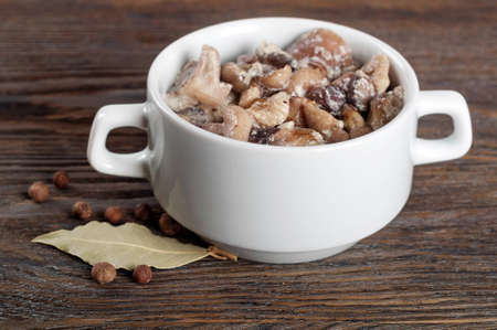 Fried with cream forest mushrooms in white plate on a wooden background.の写真素材