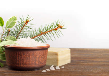 Aromatic bath salt in a clay cup on a wooden backgroundの写真素材
