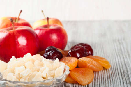 Ripe red apples, dates and dried fruits on a wooden backgroundの写真素材