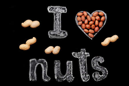 Peanuts on a black background and chalk inscription "I love nuts"の写真素材