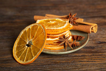 Dried orange slices, cinnamon and star anise on a brown wooden background. Spices for mulled wine.の写真素材