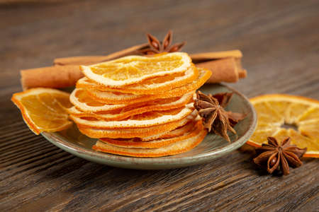Dried orange slices, cinnamon and star anise on a brown wooden background. Spices for mulled wine.の写真素材