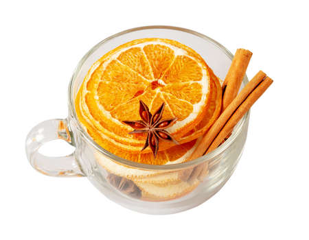 Stack of dried orange slices, cinnamon and star anise in a glass cup. Spices for mulled wine on a white background. Top viewの写真素材