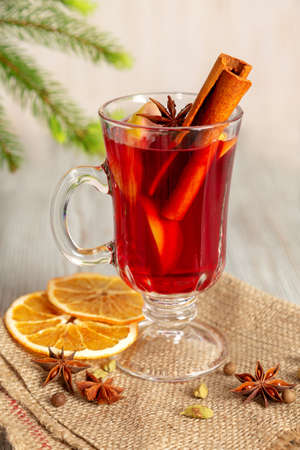 Mulled wine with spices and fruit on a wooden table. Christmas hot drink with red wine, oranges and cinnamon. Tradition holiday menu.の写真素材