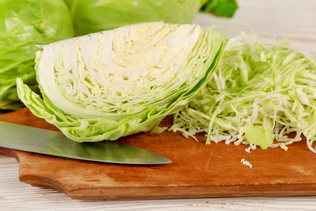 Fresh white cabbage and chopped cabbage for salad on a wooden cutting board. Vegetarian and healthy diet food concept.の写真素材