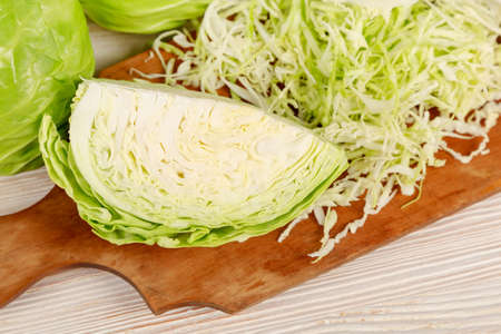 Fresh white cabbage and chopped cabbage for salad on a wooden cutting board. Vegetarian and healthy diet food concept. Top viewの写真素材