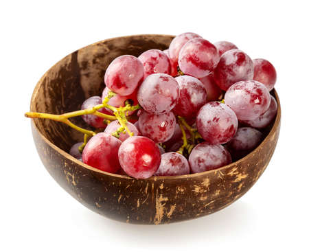 Bunch of ripe red grapes in a coconut bowl on a white backgroundの写真素材