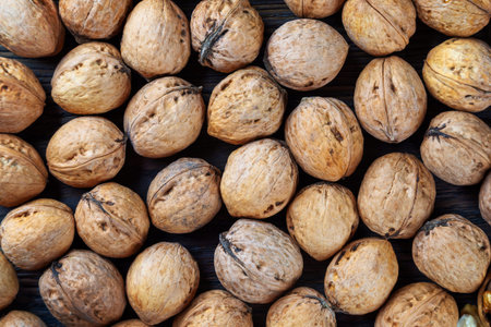 Walnuts on a brown wooden background. Whole nuts, top view
