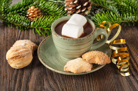 Hot chocolate, Christmas traditional cocoa drink, sweet cookies and decorations on a brown wooden background.の写真素材