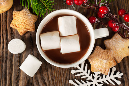 Hot chocolate or cocoa drink with marshmallow in a white cup, sweet homemade cookies and decorations...