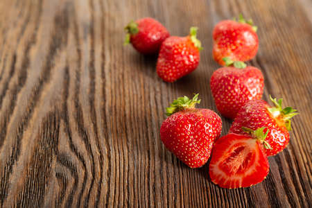 Fresh juicy ripe red strawberry on a brown wooden backgroundの写真素材