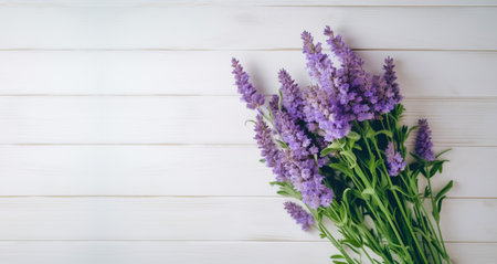 Beautiful bouquet of fresh lavender flowers with copy space for your text. Top view of lavender flowers on white wooden background. AI-Generated imageの素材