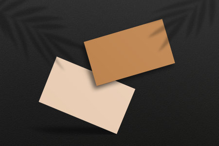 Mockup paper business cards. Paper mockup with realistic shadows overlaying paper on a wooden background. Tropical plant shade.の写真素材