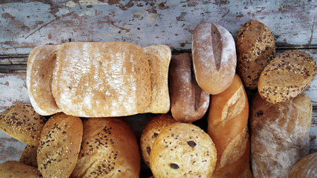 Variety of baked sourdough bread on wooden table loaf of artisan bread .Fresh fragrant bread on the table. Food concept . Different types of bread. Healthy food.の写真素材