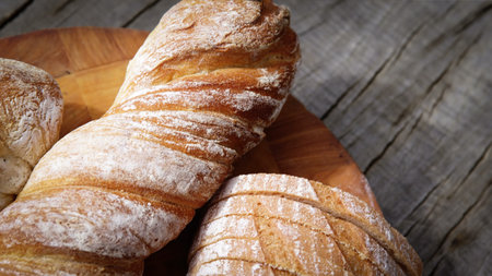 Variety of baked sourdough bread on wooden table loaf of artisan bread .Fresh fragrant bread on the...