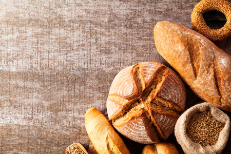 Assortment of baked bread on wooden table background