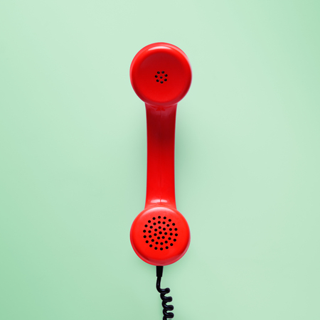 Red telephone in retro style on green background.の写真素材