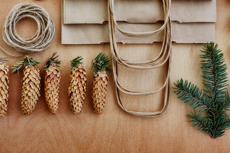 Fir cones and Kraft paper on wooden background. の写真素材