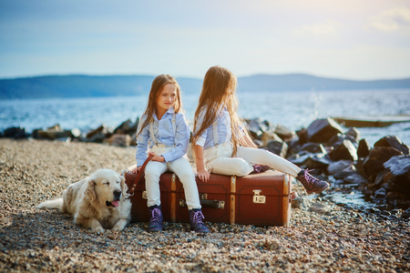 Two little twin sisters on a walk with dog の写真素材