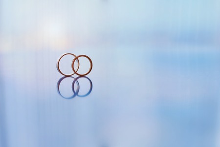 Two gold wedding rings reflectedの写真素材