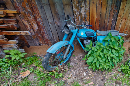 An old abandoned motorcycle stand near a fence in the villageの写真素材