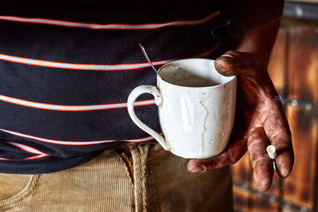 Worker holds a Cup and a cigarette during a smoke break.の写真素材