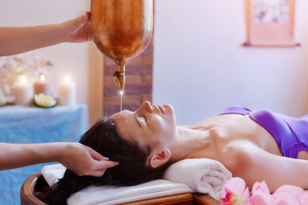 Young woman having pouring oil massage  spa treatment. Shirodhara Pouring oil on head. Treatment of headの写真素材