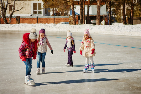 Four friends have fun at the rink.の写真素材