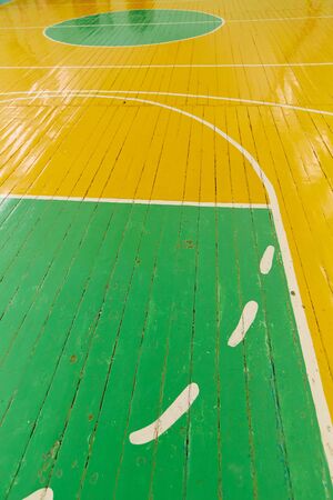 Old cracked floor of the sports hall with markings for basketball.の写真素材