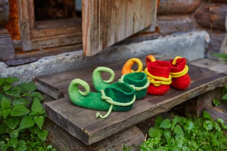 Two pairs of dwarf felt shoes at the entrance of an old wooden house. Dwarves came to visit.の写真素材