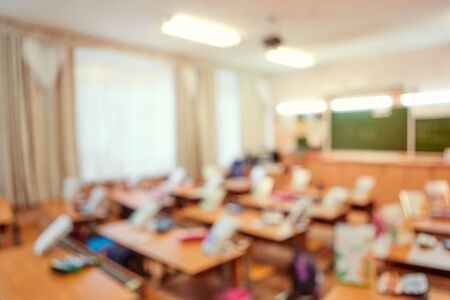 Back to school concept. Classroom in blur background without young student. Blurry view of elementary class room no kid or teacher with chairs and tables in campusの写真素材