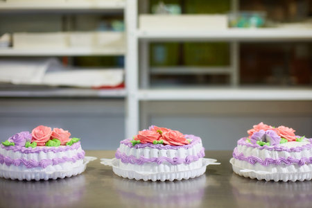 The process of decorating cakes in a pastry shop. A pastry chef makes flowers out of cream