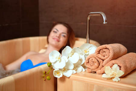 A woman who has Spa treatment and recreation in a wooden hot tub made of cedar.の写真素材
