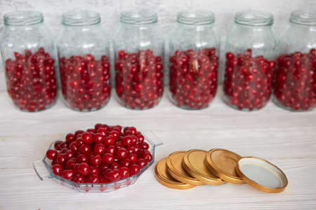 Preserving cherries in glass jars for the winter or in case of self-isolation in quarantine. Homemade fruit stocks in their own juice. Cherry compote with your own hands.の写真素材