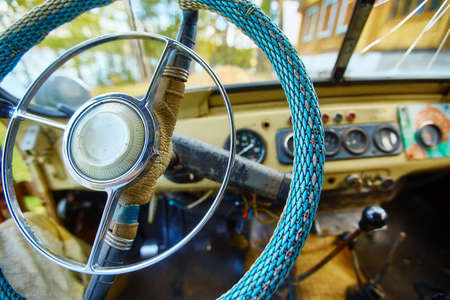 Vintage interior of an old car with a retro dashboard and steering wheel in a PVC cover.の写真素材