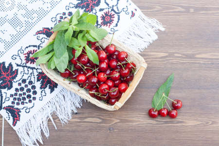 Fresh cherries and mint on embroidered towelの写真素材