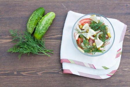 Salad of cooked squid fresh vegetables and herbs in glass bowlの写真素材