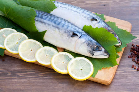 Fresh mackerel in grape leaves with lemon slicesの写真素材