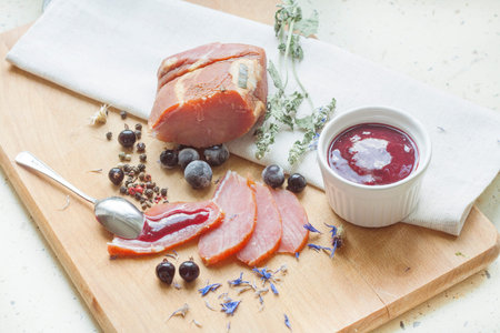 Smoked meat with currant sauce and spices on a wooden boardの写真素材
