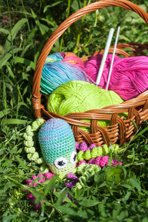 Basket with skein and knitting toy little octopus, selective focusの写真素材