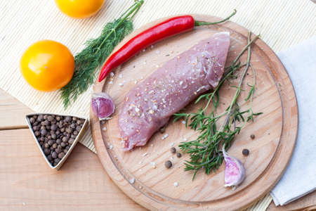Raw pork tenderloin with spices on a wooden board, selective focusの写真素材