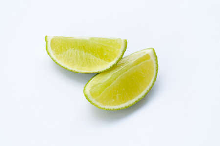 Limes with slices isolated on white backgroundの写真素材