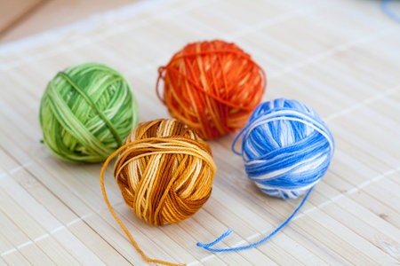 Colorful clews and crochet hook on wooden background