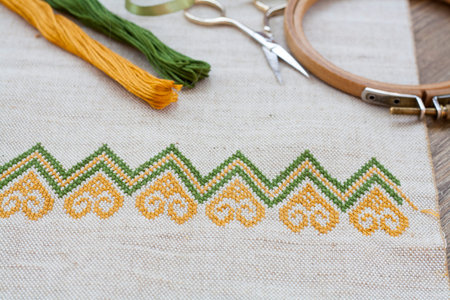 Ukrainian embroidery on the linen fabric and thread embroidery on a wooden table