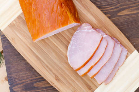 Tasty ham smoked whole and sliced close-up, selective focusの写真素材