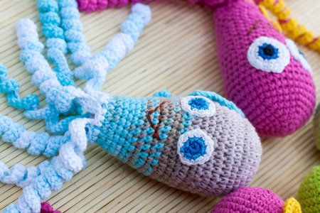 Crocheted woven with colored wool toy octopus close-up, selective focus