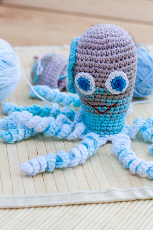 Crocheted woven with colored wool toy octopus close-up, selective focusの写真素材