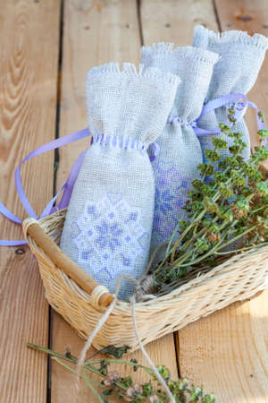 Sachet with ukrainian embroidery, sheaf of wheat and dried herbs on wooden backgroundの写真素材