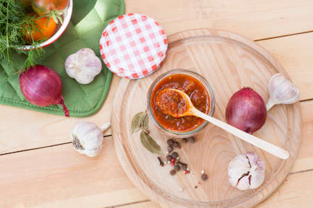 Homemade tomato sauce in glass jar with fresh tomatos, garlic, onion, herbs and spicesの写真素材