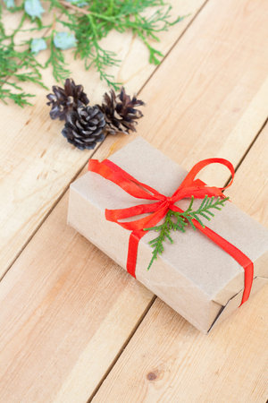 Christmas Gift, nuts, cones and green arborvitae branch on a wooden tableの写真素材